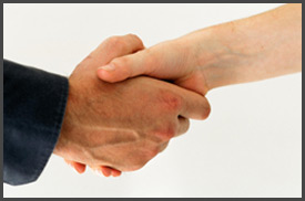 Two people shaking hands in a close up picture.